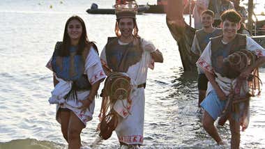Un grupo de personas sale del agua vestidos de fenicios durante uno de los actos de Cádiz Fenicia.