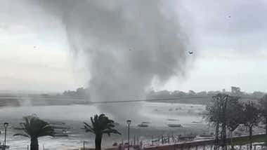 Tornado sobre el agua marina entre unas barcas y palmeras