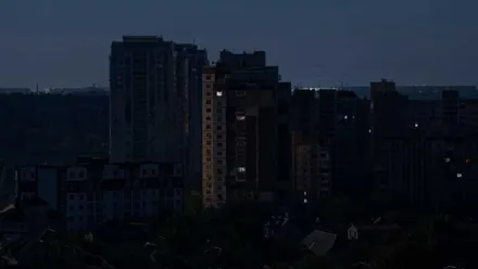 Un bloque de viviendas a oscuras, solo la silueta, al fondo el cielo.