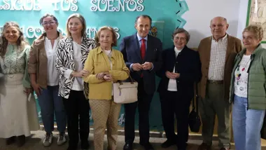 Delante de un fondo turquesa y blanco el equipo municipal de Chiclana y los responsables del CEIP Serafina Andrades.