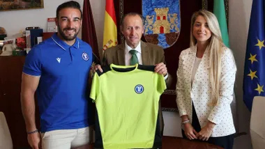 José María Román, junto a la delegada de Deportes, Isabel Butrón, y el responsable de Eleven Internacional, Miguel Chamorro, sostienen una camiseta amarilla verdosa del Clinic.