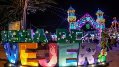 Portada de la Feria de Vejer con unas letras coloridas con el nombre de la localidad.
