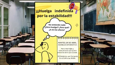 Aula vacía y cartel en amarillo sobre la asamblea de la huelga de interinos.