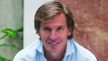 Pablo Otero con camisa clara y fondo de mármol rosa.