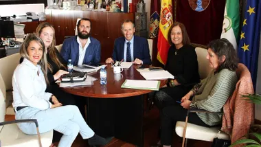 Reunión de un grupo de personas junto al alcalde de Chiclana, en su despacho, con las banderas de España y Andalucía al fondo.