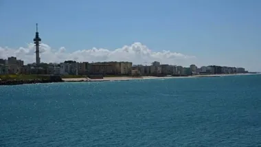 Playa de Cádiz, con cielo azul y el Pirulí al fondo