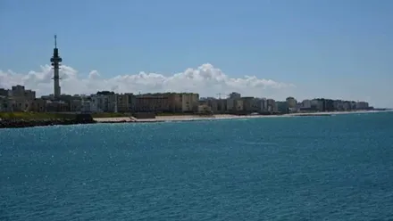 Playa de Cádiz, con cielo azul y el Pirulí al fondo