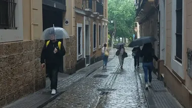 Varias personas con paraguas por la calle en Cádiz