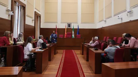 Salón del Ayuntamiento de Chiclana en madera y tonos rojos, reunión de los colectivos con Guillermo Sierra.