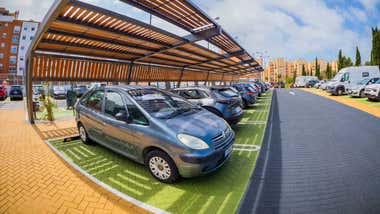 Coches aparcados en un parking renovado de San Fernando donde destacan las sombras.