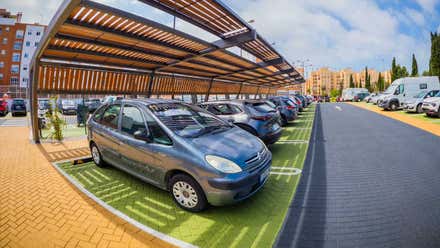 Coches aparcados en un parking renovado de San Fernando donde destacan las sombras.