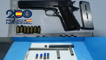 Pistola y arma de fabricación casera expuestas por la policía sobre paño celeste y regla de dimensiones.