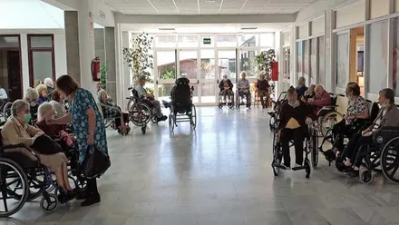 Ancianos en el asilo de San Fernando sentados y hablando entre ellos.