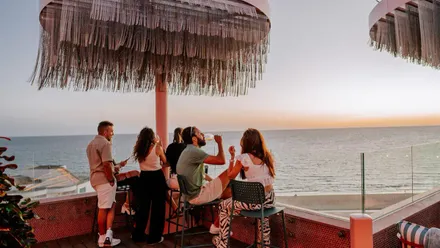 Un grupo de personas disfruta de una puesta de sol en Atardeo