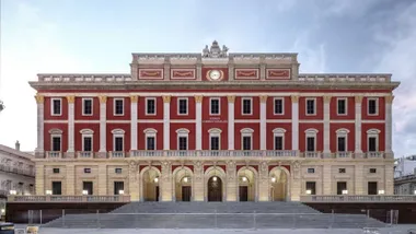 Edificio del Ayuntamiento de San Fernando en tono almagra y arena, con muchas ventanas, un edificio muy grande.