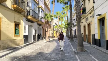 Una joven camina por una casi desierta calle de la Palma de Cádiz.