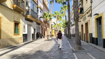 Una joven camina por una casi desierta calle de la Palma de Cádiz.