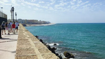 Un grupo de personas camina por el Paseo del Vendaval de Cádiz.