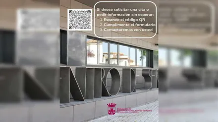 Vista de la información y acceso a la web de Chiclana para cita previa, es una fachada de un edificio con letras en acero.
