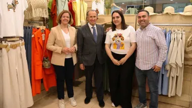 Los propietarios de la tienda junto al alcalde de Chiclana y la delegada. Están delante del escaparate y junto a un perchero con ropa.