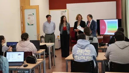 Alumnos y los miembros del Ayuntamiento en una de las aulas, destaca los ordenadores y la atención prestada por todos.