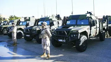 Vehículos en verde y soldados vistiendo uniforme color tierra en el día de las Fuerzas Armadas de San Fernando.