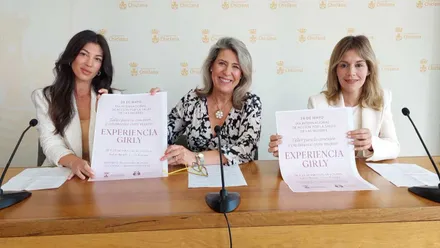Tres mujeres, la delegada y responsables del taller presentando el cartel que sostienen en las manos.