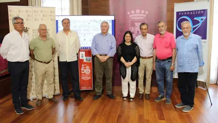 Representante municipal y otras personas implicadas en la exposición virtual ‘50 años de la creación del Club Náutico Sancti Petri’. Posan delante de una pantalla.