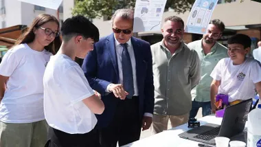 El alcalde de Chiclana junto a más personas, vestido de chaqueta y corbata en la Feria de las Ciencias.
