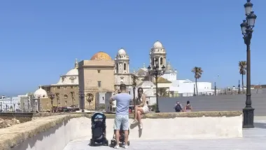 Turistas haciéndose fotos en el Campo del Sur de Cádiz con la Catedral de Fondo