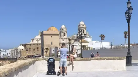 Turistas haciéndose fotos en el Campo del Sur de Cádiz con la Catedral de Fondo