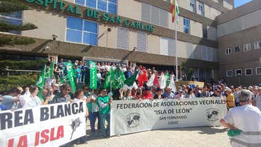 Manifestantes en la entrada del Hospital San Carlos de San Fernando con pancartas, muchos de ellos con el uniforme del hospital en verde o en blanco.