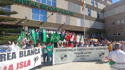 Manifestantes en la entrada del Hospital San Carlos de San Fernando con pancartas, muchos de ellos con el uniforme del hospital en verde o en blanco.
