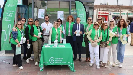 Miembros de AECC y el alcalde de Chiclana, destacan los tonos verdes, están en la mesa en la Plaza.