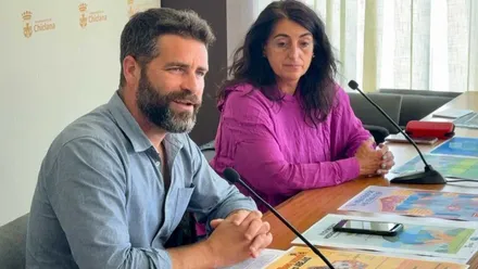 Roberto Palmero y Cristina Ciancas apoyados en una mesa presentando el programa de educación medioambiental.