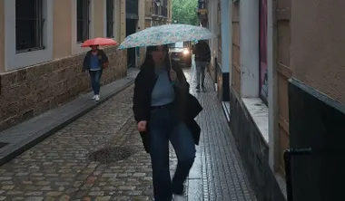 Una joven con un paraguas por las calles de Cádiz