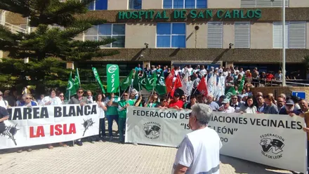 Diferentes manifestantes portando pancartas de protesta en el Hospital San Carlos.