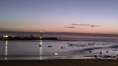 Anochece en la playa de La Caleta de Cádiz, con el Castillo de San Sebastián al fondo