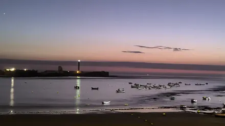 Anochece en la playa de La Caleta de Cádiz, con el Castillo de San Sebastián al fondo