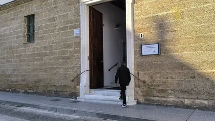 Una persona sube el acceso a la Residencia de Mayores Fragela, de Cádiz.