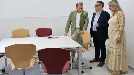En una habitación blanca con sillas rojas y color madera están José María Román, Francis Salado y Mª. Ángeles Martínez Rico en las nuevas instalaciones.