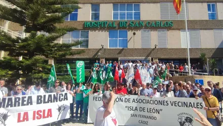 Manifestantes con pancartas de color verde o blanca y letras negras y rojas en el hospital San Carlos.