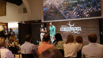 José María Román con camisa verde habla desde el salón del Vino y la Sal.
