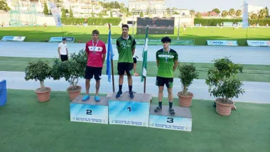 Atletas en el podio, el primero y el tercero de verde y el segundo con indumentaria roja.