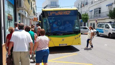 Autobús amarillo y verde con destino Chiclana - Sancti Petri al que suben pasajeros.