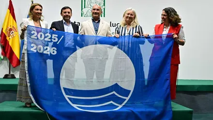 Mercedes Colombo junto a otras personas sostienen con sus manos la bandera azul.