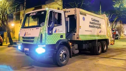 Camión blanco y verde de recogida de basura en San Fernando.