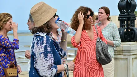 Una mujer bebe de una botella de agua en un día de mucho calor en Cádiz.