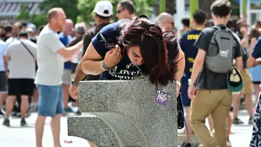 Una joven bebe agua en una de las fuentes públicas de Cádiz.