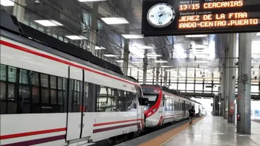 Estación con trenes de Cercanías de Renfe con destino a Jerez en una pantalla luminosa.